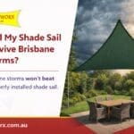 Alt Text: Triangle shade sail installed over Brisbane outdoor patio during storm conditions — storm-ready and properly tensioned